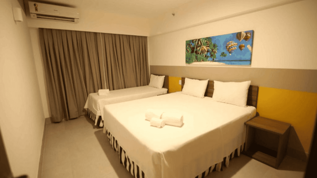 Quarto acolhedor e convidativo no Enjoy Olímpia Park Resort, com cama de casal confortável, área de estar com sofá e decoração vibrante.